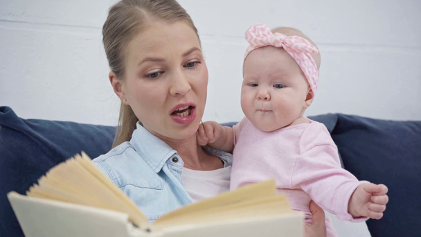 attractive mother reading book to infant  - Footage, Video