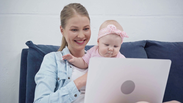 madre feliz y el bebé mirando a la computadora portátil
  - Metraje, vídeo