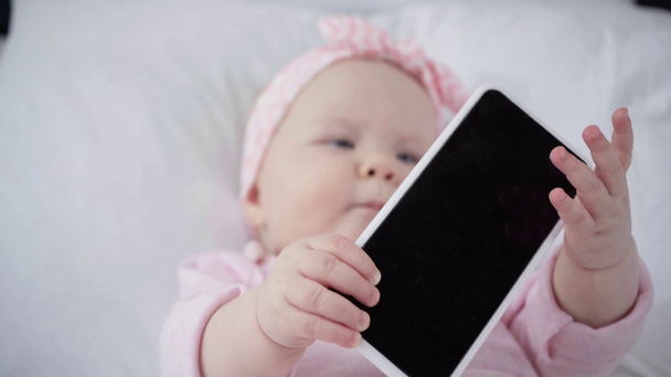 rack focus of infant holding smartphone with blank screen  - Footage, Video