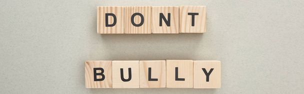 panoramic shot of wooden blocks with dont bully lettering on grey background - Фото, изображение