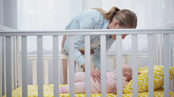 счастливая мать кладет младенца в детскую кроватку
  - Кадры, видео