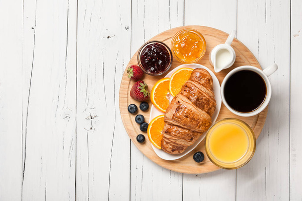 Breakfast with croissants, coffee, orange juice, fruits and berr - Photo, image