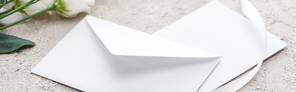 panoramic shot of envelope near eustoma flowers and white ribbon on grey textured surface   - Foto, Imagem