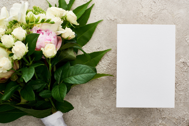 top view of blank invitation card near bouquet on textured surface - Φωτογραφία, εικόνα