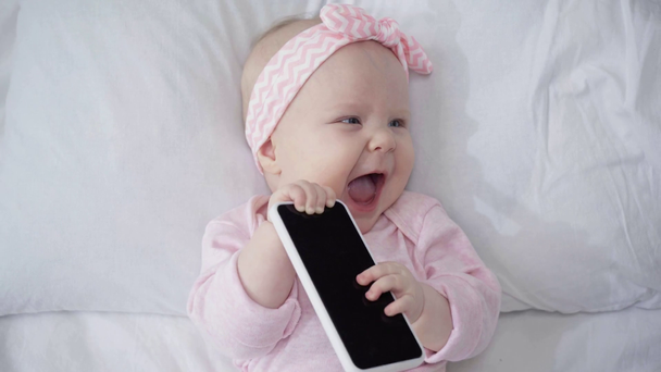 top view of baby holding smartphone with blank screen  - Footage, Video
