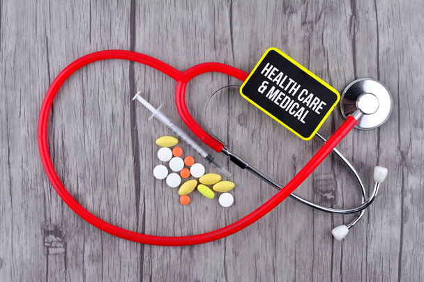 Pilules, seringues et stéthoscope avec texte Soins de santé et soins médicaux
 - Photo, image
