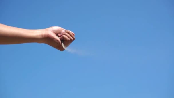 Homok áramlik a kezét ég háttérben - Felvétel, videó