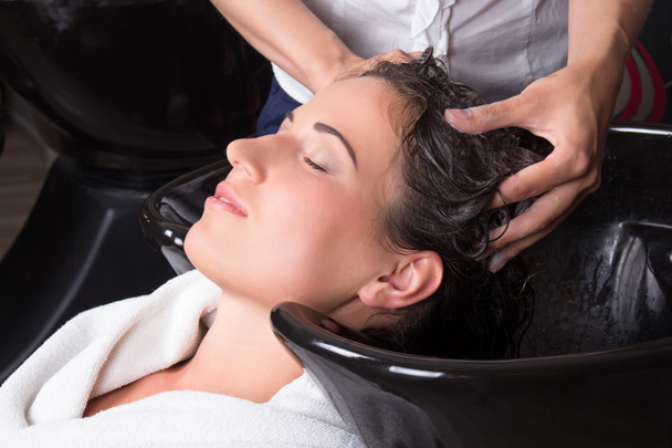 mladá atraktivní žena dostává mytím vlasů v salonu - Fotografie, Obrázek