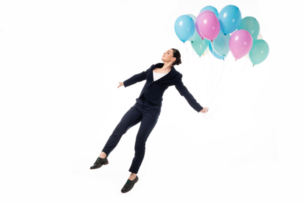 attractive businesswoman in woman levitating with festive balloons isolated on white - Photo, Image
