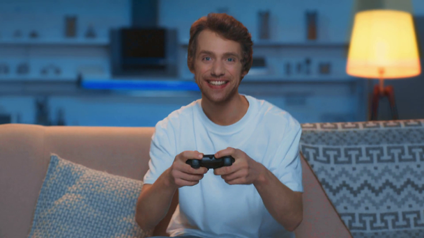 KYIV, UKRAINE - MARCH 12, 2019: guy playing video game and showing yes gesture in living room - Footage, Video