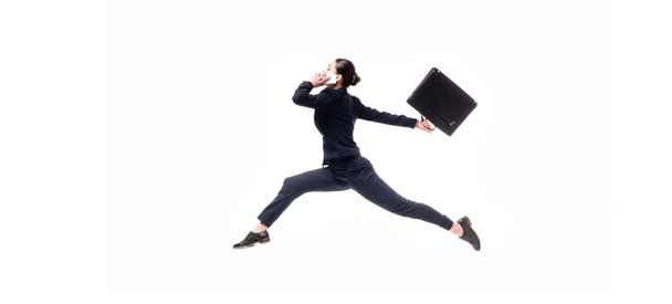 panoramic shot of young businesswoman with briefcase levitating while talking on smartphone isolated on white - 写真・画像