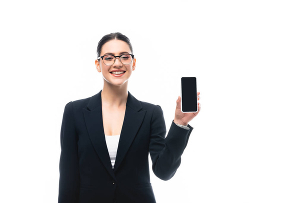 cheerful businesswoman presenting smartphone with blank screen isolated on white - Photo, Image
