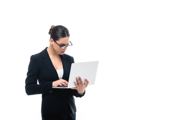 concentrated businesswoman in glasses using laptop isolated on white - Foto, Bild