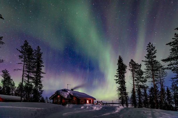 Πολικό αρκτικό Βορρά φώτα Aurora βόρειο σέλας δραστηριότητα πάνω από ξύλινο σπίτι το χειμώνα Φινλανδία, Λαπωνία - Φωτογραφία, εικόνα