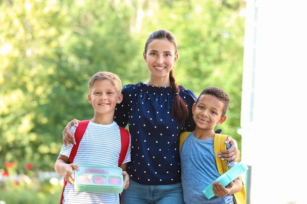 Portrait of mother and her little sons with school lunch outdoors - Photo, Image