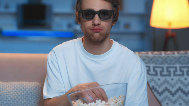smiling man in 3d glasses eating popcorn and watching tv - Video, Çekim