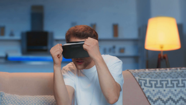 fiatal férfi a VR headset boksz a nappaliban - Felvétel, videó