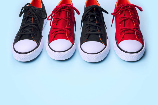 Новые черные и красные кроссовки на бледно-синем фоне с копировальным пространством
. - Фото, изображение