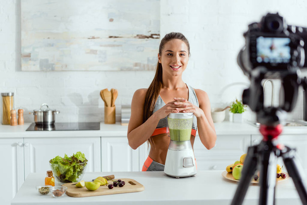 selective focus of happy woman near blender with smoothie  - Foto, Imagen