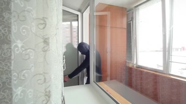 Rablás egy lakásban. A lakás tolvaj lépett át az erkélyen. Főoldal betörő a tolvaj belépett a lakásban az erkélyen. - Felvétel, videó