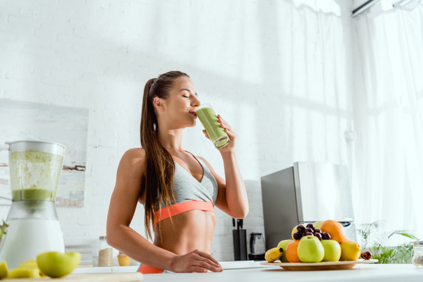 low angle view of girl drinking green fresh smoothie  - Photo, Image