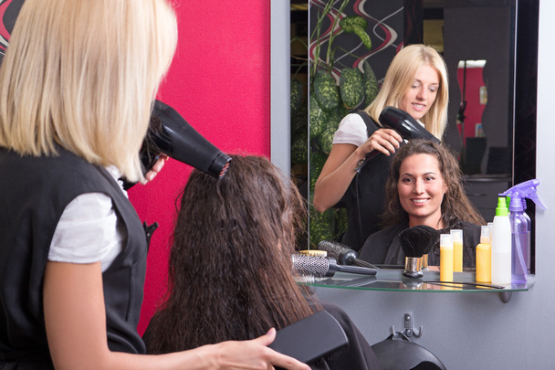 jovem cabeleireiro faz penteado para a menina bonita - Foto, Imagem