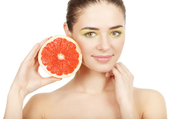 Beauty. Young beautiful woman holding grapefruit - Foto, afbeelding