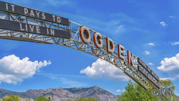 Panorama frame O arco de boas-vindas em Ogden Utah contra árvores vibrantes e montanhas imponentes
 - Foto, Imagem