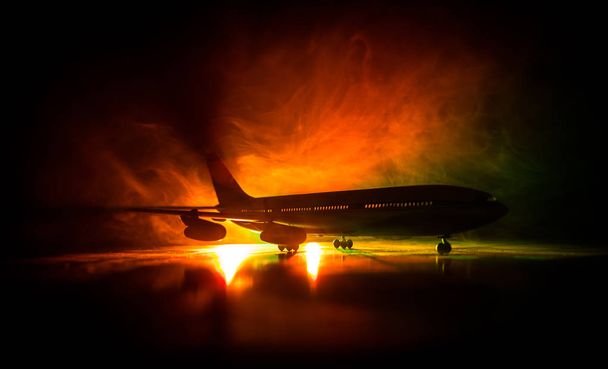 Artwork decoration. White passenger plane ready to taking off from airport runway. Silhouette of Aircraft during night time. - Foto, Imagen