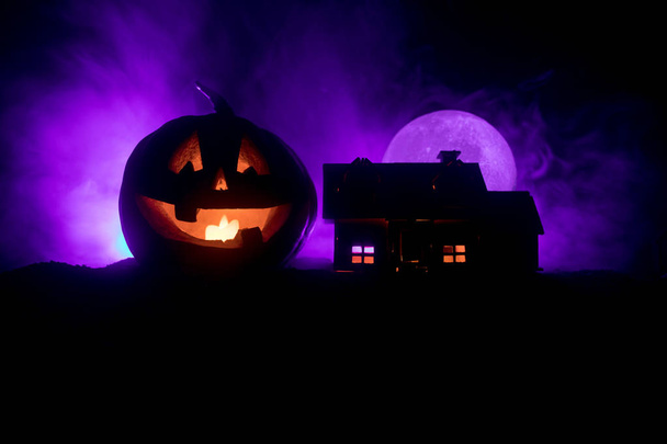 Vista dell'orrore della zucca di Halloween con la faccia sorridente spaventosa. Lanterna jack testa con edificio spettrale
 - Foto, immagini