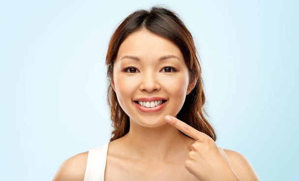 happy smiling young asian woman touching her face - Photo, Image