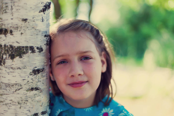 Piękna dziewczyna w wieku 9 lat w sukience w brzozy. - Zdjęcie, obraz