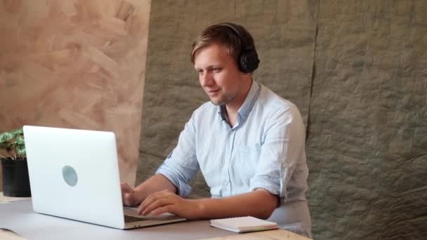Man typing on laptop keyboard, listening to music in headphones and singing. Freelance, coworking, business, office, funny, joke. - Metraje, vídeo
