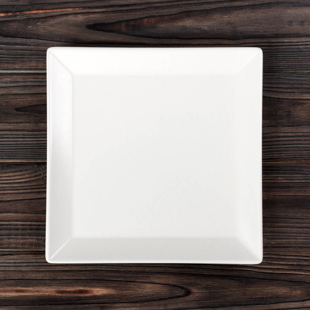 White square Plate on wooden table background. Perspective view - Foto, Bild