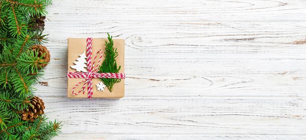 リサイクル紙に包まれたクリスマスギフトボックスで、リボンの弓で、素朴な背景にリボンが付いています。ホリデーバナーコンセプト - 写真・画像