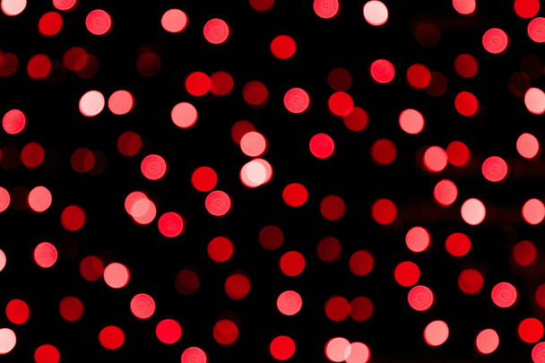 Nezaměřená abstraktní červená bokeh na černém pozadí. zaostřené a rozmazané mnohé kulaté světlo - Fotografie, Obrázek
