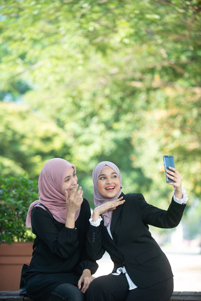 Femmes d'affaires musulmanes prenant un selfie. Réglage extérieur
. - Photo, image