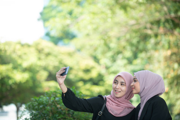 Femmes d'affaires musulmanes prenant un selfie. Réglage extérieur
. - Photo, image