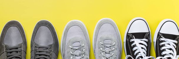 Набор модной мужской обуви на желтом фоне
 - Фото, изображение