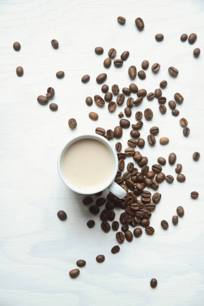 Flatlay taza de café y granos de café sobre un fondo blanco
 - Foto, imagen
