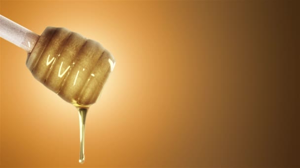 Honey dripping from honey dipper on orange background - Footage, Video
