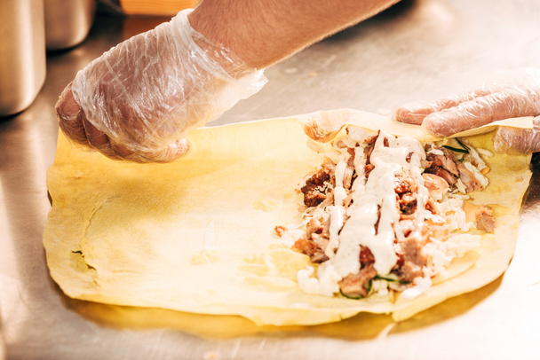 vista parziale di cuoco in guanti preparazione doner kebab
 - Foto, immagini