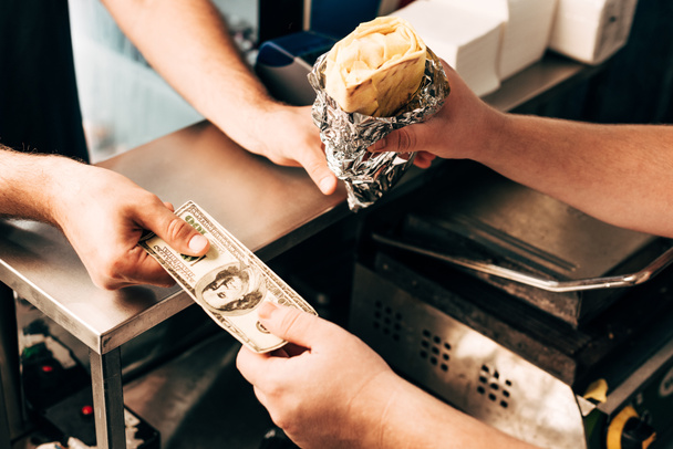 cropped view of man buying doner kebab in aluminium foil - Photo, Image