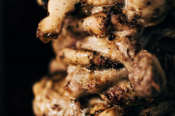Close-up uitzicht op heerlijk vlees op Rotisserie geïsoleerd op zwart - Foto, afbeelding