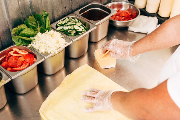 vue recadrée du cuisinier dans les gants préparation doner kebab
 - Photo, image