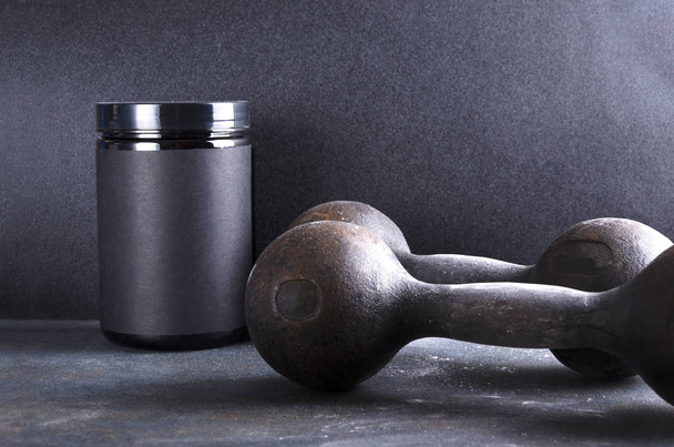 Concept of sorty lifestyle.Special sport supplements and old dumbbells - Photo, Image