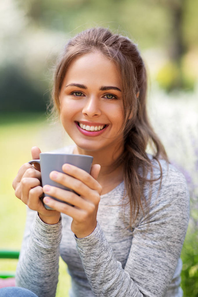woman drinking tea or coffee at summer garden - Zdjęcie, obraz