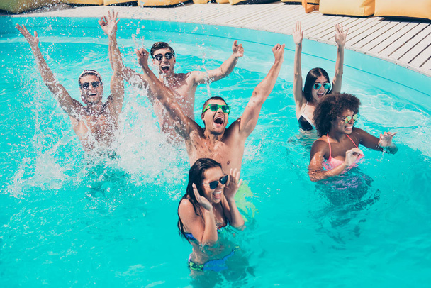 Foto de seis amigos multinacionais brincando na água desfrutando melhor companhia e tempo ensolarado perfeito
 - Foto, Imagem