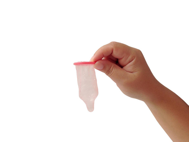 Рука жінки тримає презерватив на білому фоні. Презерватив для безпеки сексом. Венеричні інфекції. - Фото, зображення