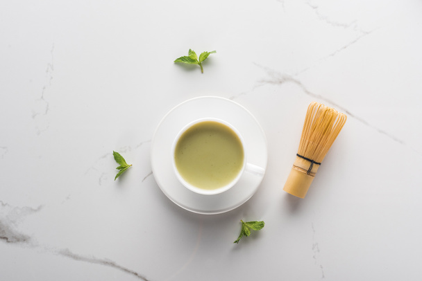 Top uitzicht van Matcha thee met mint op witte tafel - Foto, afbeelding